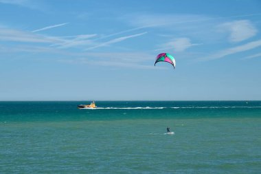 Ramsgate 'deki turkuaz denizde bir uçurtma sörfçüsü ve arka planda bir pilot teknesi.