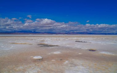 Uyuni Salt Flat 'in arka planda bulutlu gündüz görüntüsü.