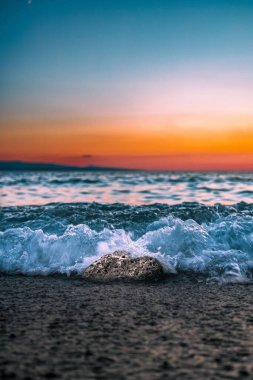 Resme bakarken denizin sesini duyabilir ve teninizdeki serinletici havayı hissedebilirsiniz. Hırvatistan 'ın Brela kentinde muhteşem gün batımı.