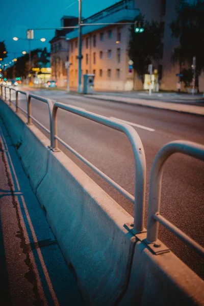 夜間の交通道路を隔てる手すりの垂直閉鎖ショット — ストック写真
