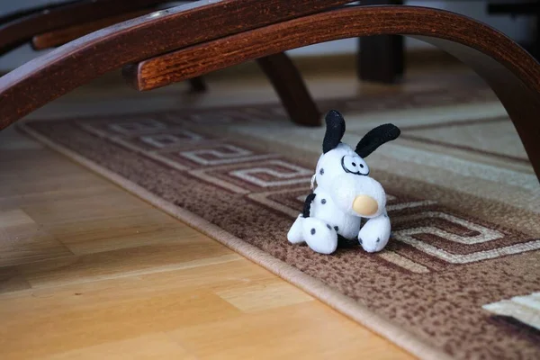 Een Witte Speelgoedhond Het Tapijt Onder Houten Stoel — Stockfoto