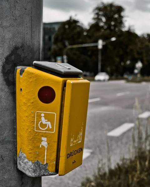 A yellow traffic light call button