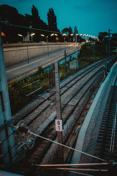Tiro Vertical Ferrovias Trem Perto Uma Estrada Com Luzes Rua — Fotografia de Stock