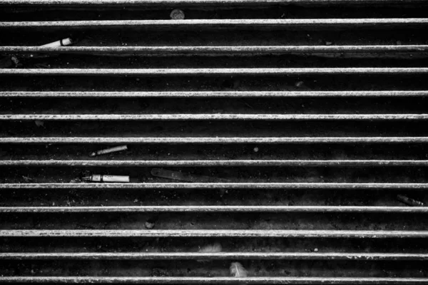 Den Närbild Gråskalan Cigaretter Mellan Metallmönsterpanelerna — Stockfoto