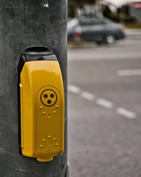 A yellow traffic light call button