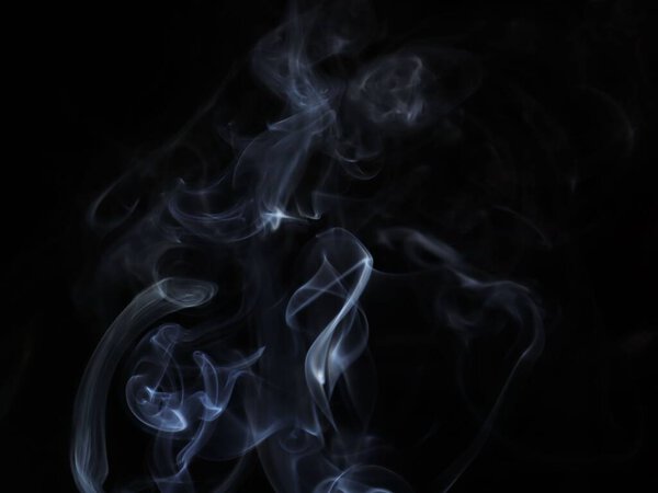 A closeup of an abstract light white smoke motion on a black background