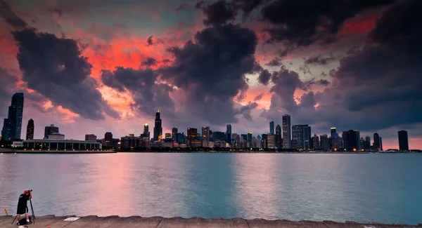 海岸沿いの近代的な都市の上に魅惑的なピンクの夕日 — ストック写真