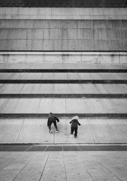 Μια Κάθετη Γκρι Φωτογραφία Δύο Παιδιά Ανεβαίνουν Τις Σκάλες — Φωτογραφία Αρχείου