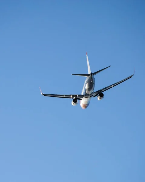 真っ青な空を飛ぶ飛行機の垂直ショット — ストック写真