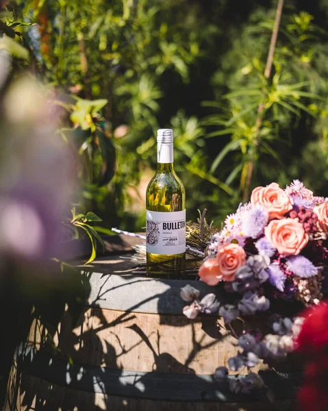 Eine Flasche Wein Auf Einem Fass Der Nähe Des Rosenstraußes — Stockfoto