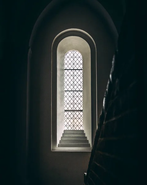 暗闇の中で階段と刻まれた石のアーチ窓の垂直閉鎖 — ストック写真