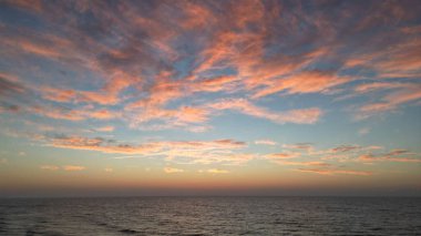 Güneşin doğuşu okyanusun üzerinde gökyüzünü güzel gösteriyor.
