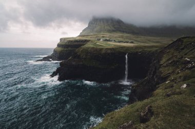Rüzgarlı ve Bulutlu Sonbahar Sonbaharı sırasında Faroe Adası Şelalesi Gasadalur.