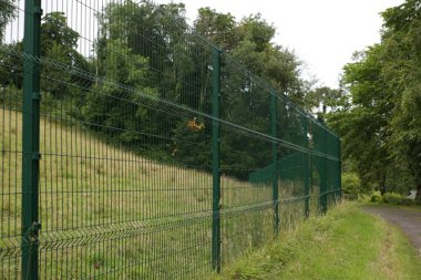 Parkta yeşil çitlerle çevrili bir alana yakın çekim.