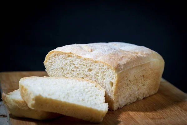 Świeżo Upieczony Krojony Bochenek Białego Chleba Drewnianej Desce — Zdjęcie stockowe
