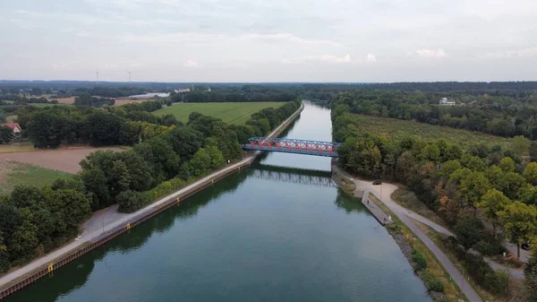 緑の銀行の間の川の上の橋の空中ビュー — ストック写真