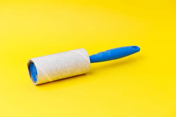 Een Blauwe Pluisrol Met Stof Erop Geïsoleerd Gele Achtergrond — Stockfoto