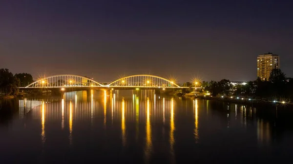德国科尔湖中 夜晚灯火通明的贝塔斯 雷纳努斯桥映照出来 — 图库照片