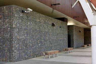 Gri taştan bir duvarda güvenlik kamerası var.