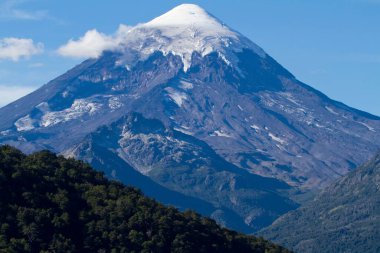 Kış boyunca tepesinde kar olan bir dağ.