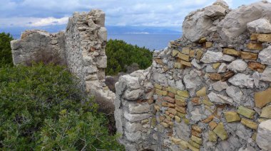 Bulutlu gökyüzünün altındaki taş bir duvarın büyüleyici görüntüsü.