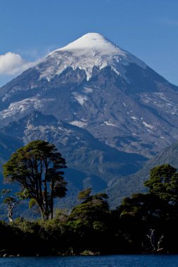 Kış boyunca tepesinde kar olan bir dağ.
