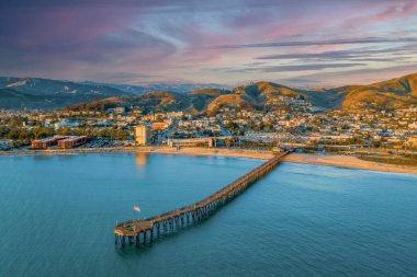 Ventura, Kaliforniya 'da günbatımında arka planda bir rıhtımın ve güzel bir kasabanın hava manzarası.