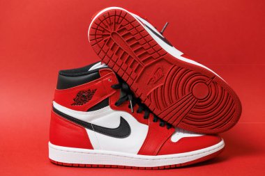 Bir çift Air Jordan 1 Sneakers yandan ve aşağıdan izole edilmiş kırmızı arka planda