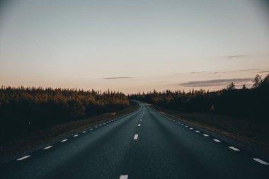 Gün batımında manzarada bir yolun büyüleyici görüntüsü.
