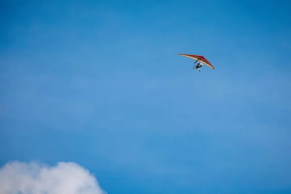 在蓝天高高地飞翔的悬挂滑翔机的照片 — 图库照片