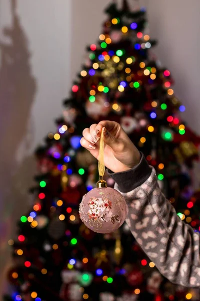 Eine Frau Hält Einen Weihnachtsschmuck Vor Einem Bokeh Licht Hintergrund — Stockfoto