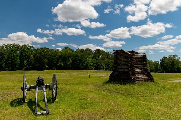 隣に木造の小さな砦を持つ野外に設置されたガトリング銃 — ストック写真