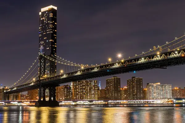 Uma Foto Baixo Ângulo Uma Ponte Iluminada Horizonte Noite Manhattan — Fotografia de Stock