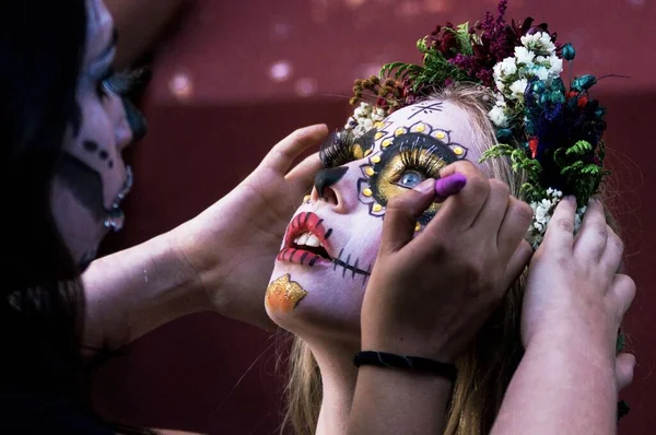 死者の日のための美しい頭蓋骨の化粧を得る女性のクローズアップショット — ストック写真