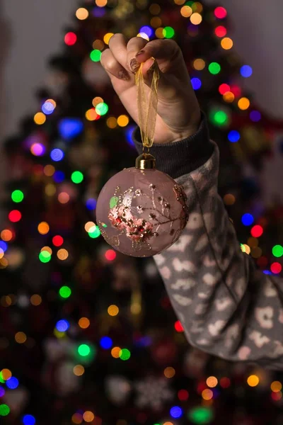 Eine Frau Hält Einen Weihnachtsschmuck Vor Einem Bokeh Licht Hintergrund — Stockfoto