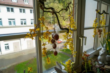 Bir odadaki pencerelerdeki paskalya süslerinin görüntüsü