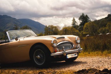 İskoç dağlarında eski bir Porsche arabası.