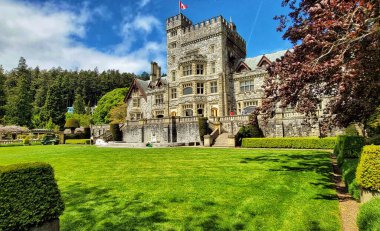 Gündüz vakti Kanada 'daki Hatley Kalesi' nin güzel simgesi yeşil bahçeli ve arka planda ağaçlarla