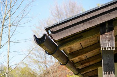 Kuru dalların arka planına karşı ahşap bir çatıya yakın çekim