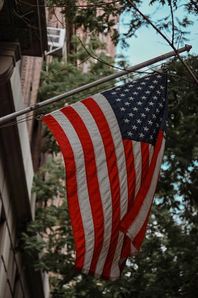 A vertical shot of the USA flag on a building
