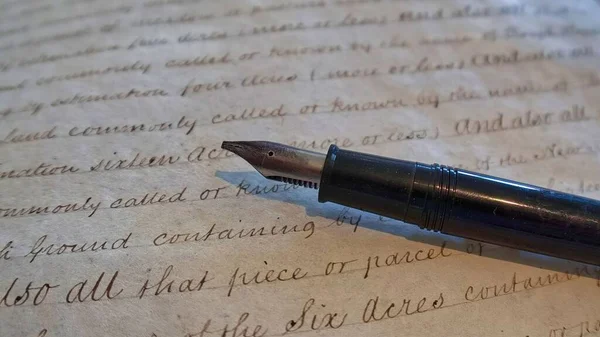 Ένα Κοντινό Πλάνο Ενός Μαύρου Στυλό Ένα Παλιό Χειρόγραφο Συμβόλαιο — Φωτογραφία Αρχείου