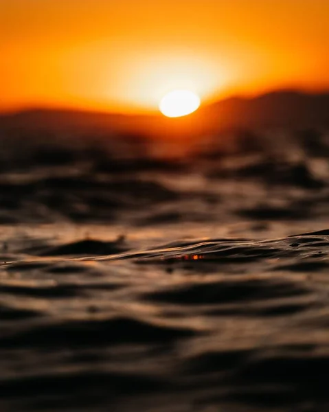 背景に夕日と海の波の選択的フォーカスショット — ストック写真