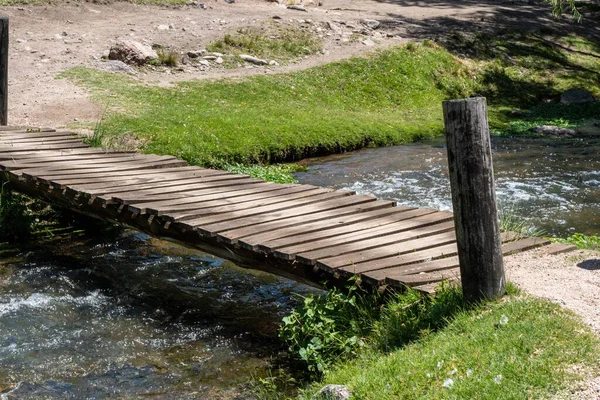 晴れた日に川を渡る小さな木製の橋の高角度ビュー — ストック写真