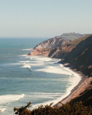 Mavi gökyüzünün altındaki sahil şeridinin dikey görüntüsü.