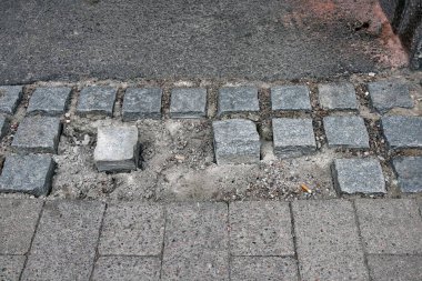 Sokak yolundaki gri gevşek kaldırım taşlarının yüksek açılı görüntüsü.