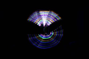 Aydınlık boya, karanlık bir göz etrafında soyut bir yörüngeyi gösteren siyah bir arkaplan oluşturur..