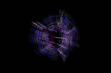 Aydınlık boya, karanlık bir göz etrafında soyut bir yörüngeyi gösteren siyah bir arkaplan oluşturur..