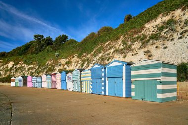 Thanet, Kent, İngiltere 'deki Dumpton Gap plajında renkli ahşap plaj kulübeleri..