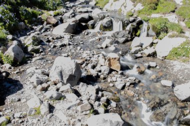 Güneşli bir günde kayaların arasından akan nehrin yüksek açılı görüntüsü.
