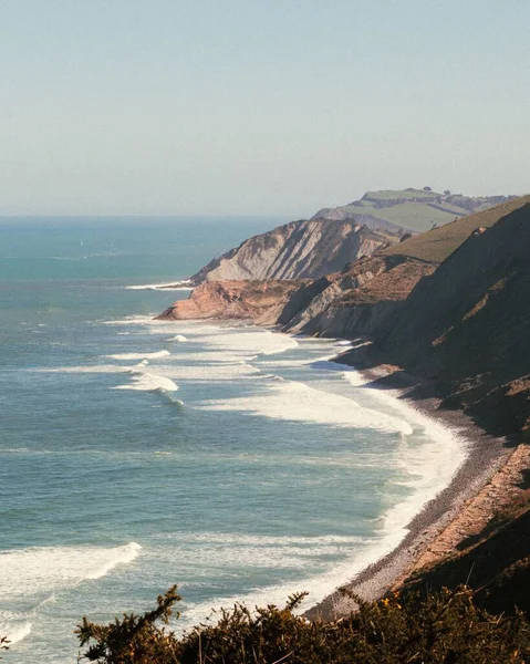 Mavi gökyüzünün altındaki sahil şeridinin dikey görüntüsü.